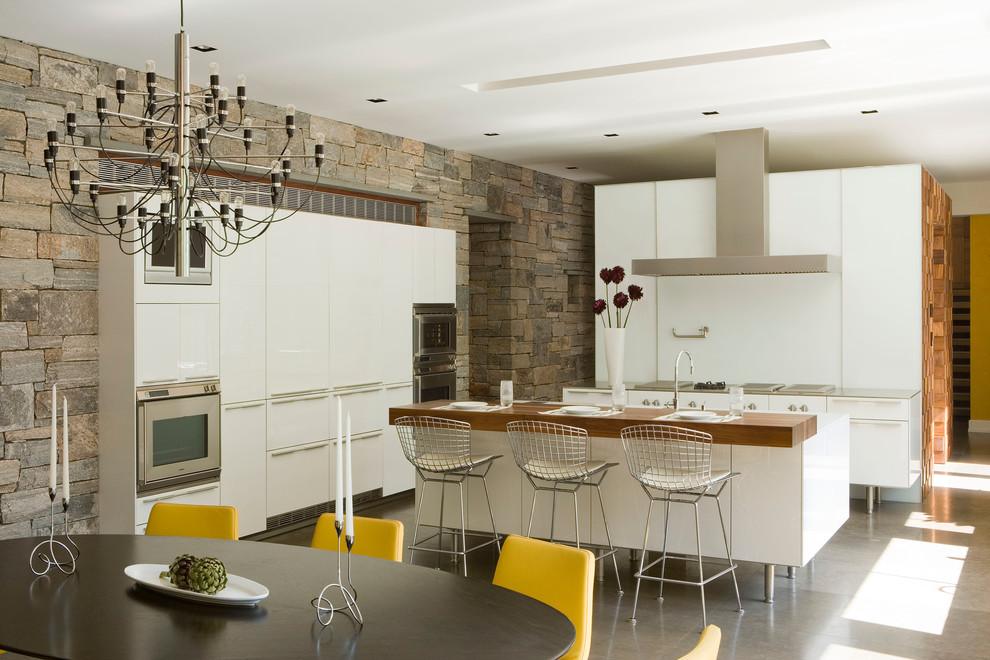 Foto di una cucina moderna con ante lisce, ante bianche, top in legno e elettrodomestici in acciaio inossidabile