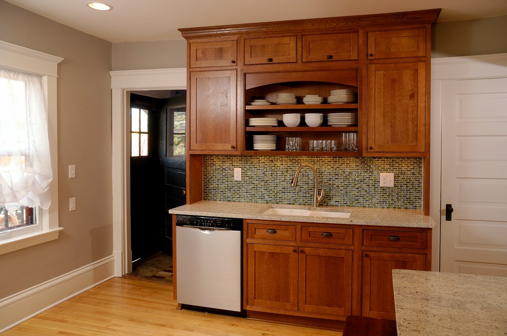 Example of a mid-sized arts and crafts u-shaped medium tone wood floor enclosed kitchen design in Minneapolis with an undermount sink, open cabinets, medium tone wood cabinets, granite countertops, green backsplash and stainless steel appliances
