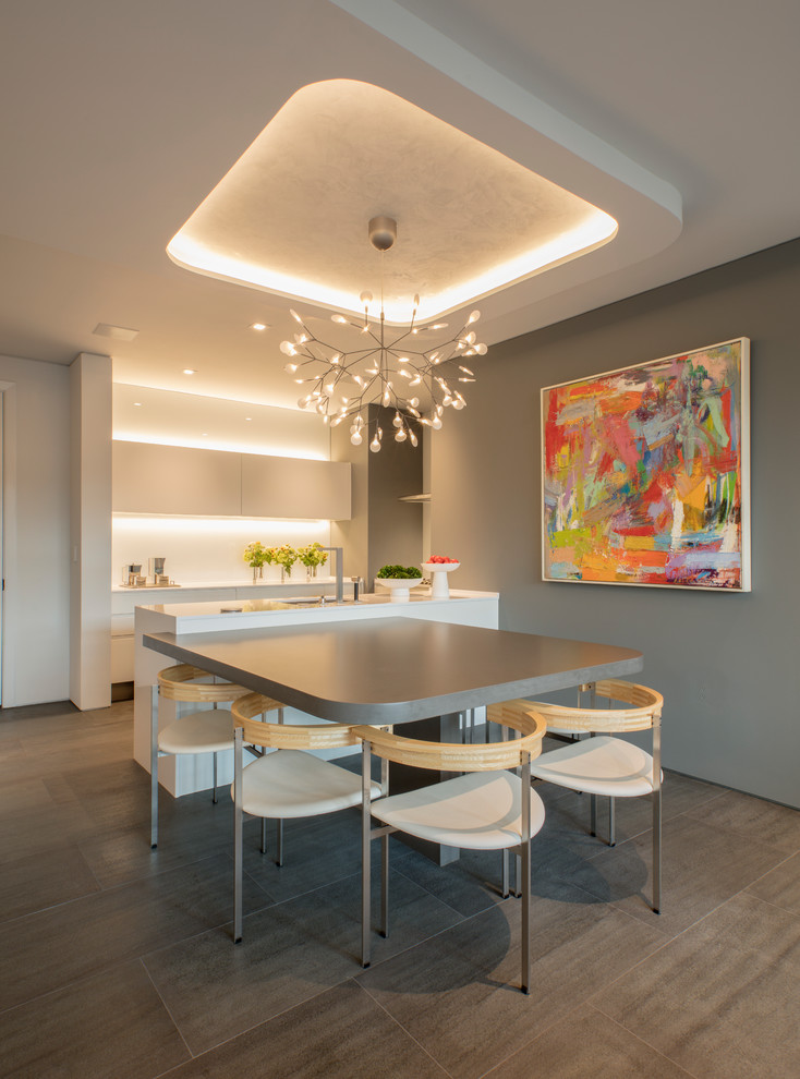 Cette photo montre une petite salle à manger ouverte sur la cuisine moderne avec un sol en carrelage de porcelaine et un sol gris.