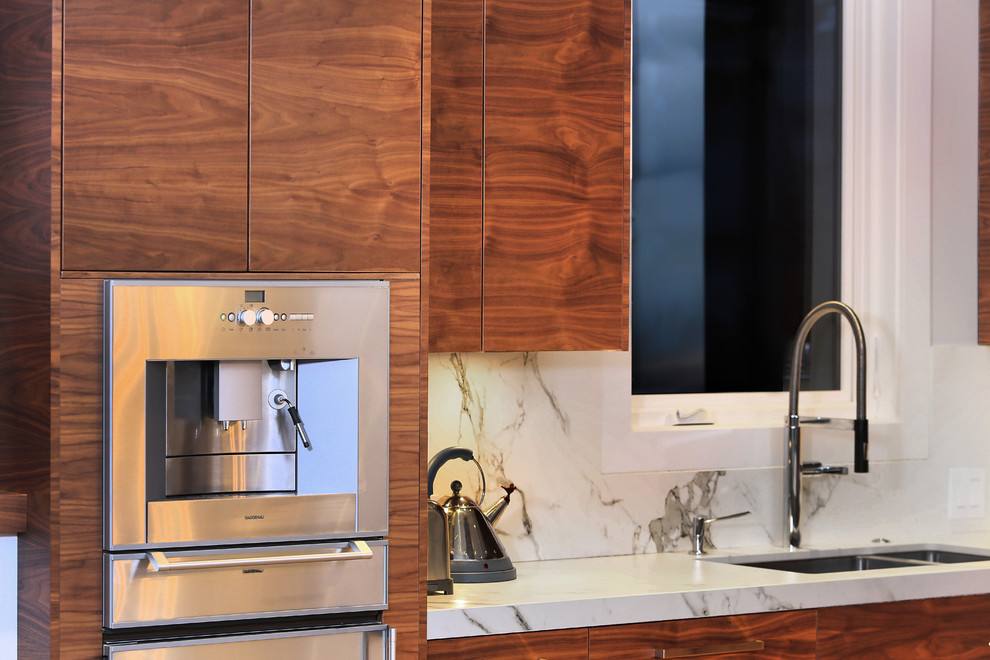 Foto di un'ampia cucina contemporanea con lavello da incasso, ante lisce, ante in legno scuro, paraspruzzi bianco, elettrodomestici in acciaio inossidabile e parquet chiaro
