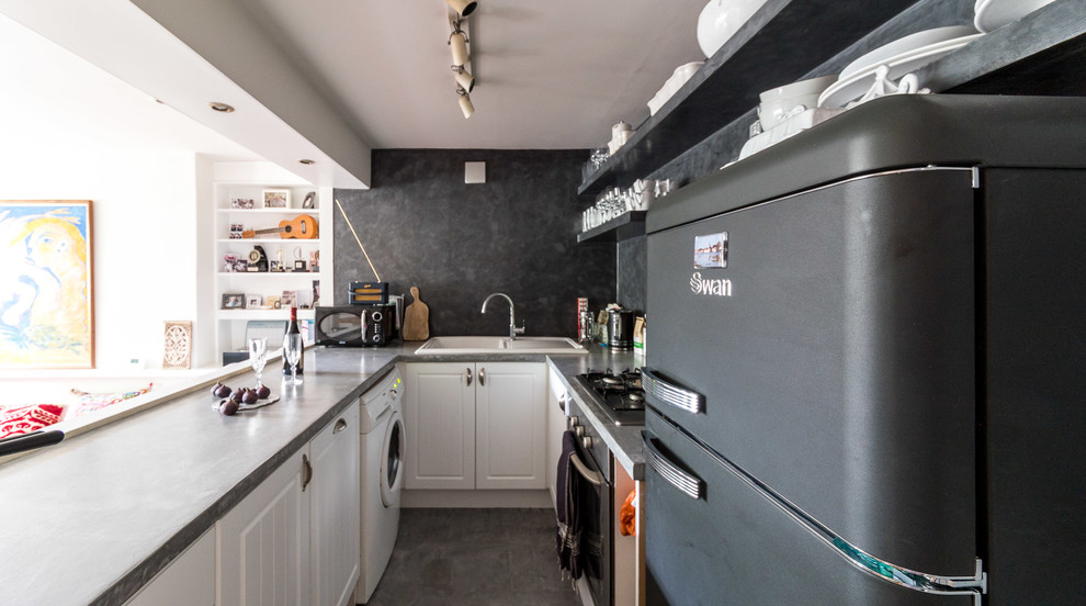 Esempio di una cucina ad U design di medie dimensioni con ante bianche e pavimento nero