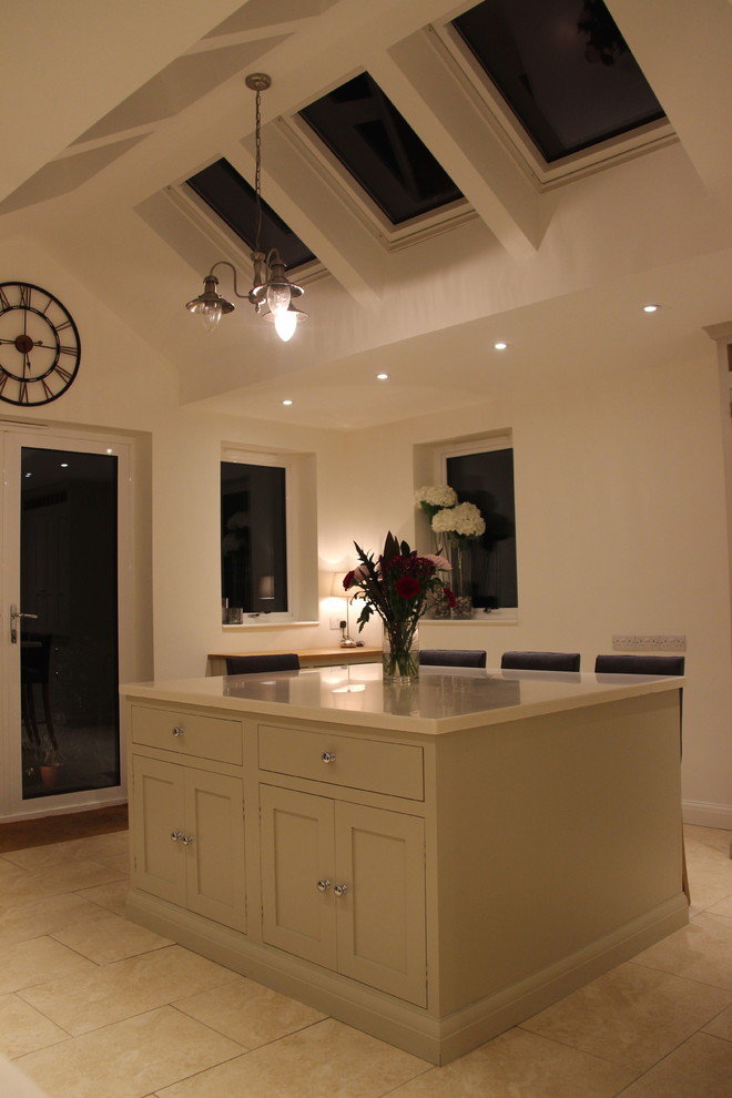 This is an example of a large traditional u-shaped kitchen/diner in Surrey with flat-panel cabinets, beige cabinets, an island and white worktops.