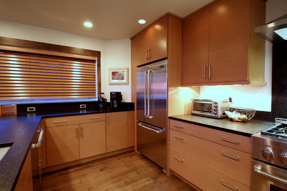 Exempel på ett modernt kök, med en undermonterad diskho, släta luckor, träbänkskiva, svart stänkskydd, stänkskydd i sten och rostfria vitvaror