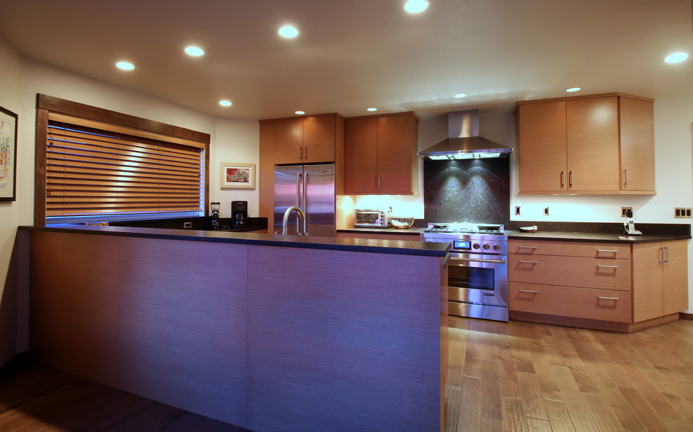 Photo of a contemporary u-shaped kitchen/diner in Other with a submerged sink, flat-panel cabinets, wood worktops, black splashback, stone slab splashback and stainless steel appliances.