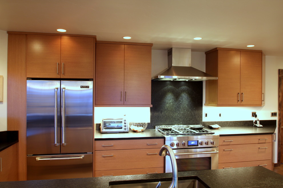 Immagine di una cucina design con lavello sottopiano, ante lisce, top in legno, paraspruzzi nero, paraspruzzi in lastra di pietra e elettrodomestici in acciaio inossidabile