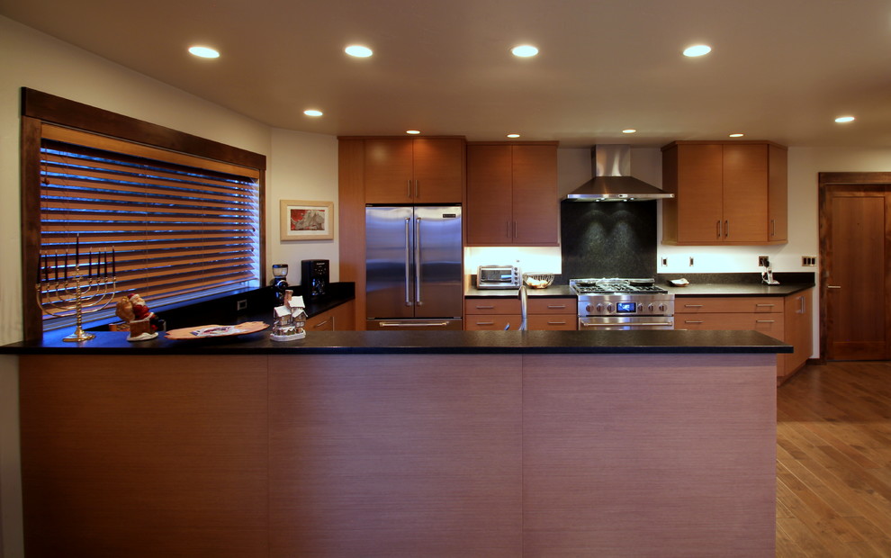 Immagine di una cucina minimal con lavello sottopiano, ante lisce, top in legno, paraspruzzi nero, paraspruzzi in lastra di pietra e elettrodomestici in acciaio inossidabile