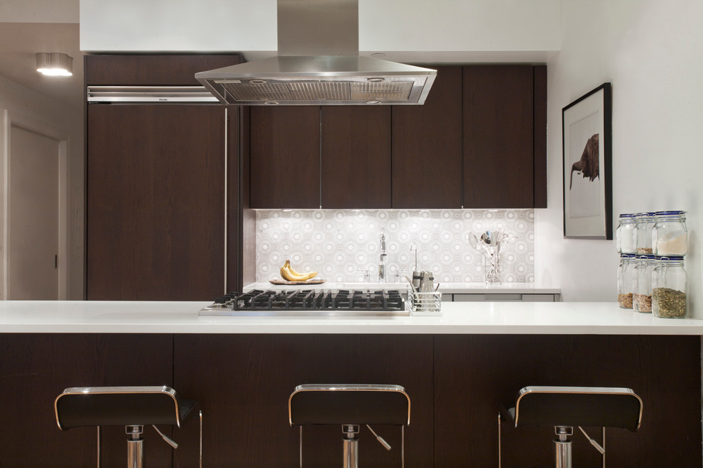 Moderne Küche mit flächenbündigen Schrankfronten, dunklen Holzschränken, Mineralwerkstoff-Arbeitsplatte und Kücheninsel in New York