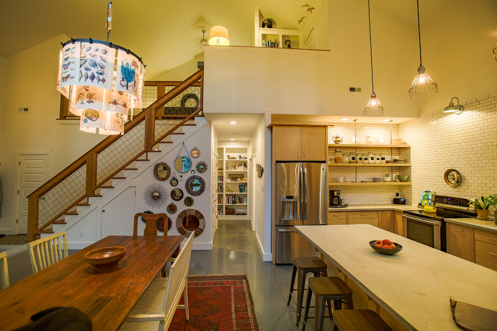Imagen de cocina de estilo de casa de campo pequeña con armarios con paneles lisos, puertas de armario de madera clara, encimera de cemento y una isla