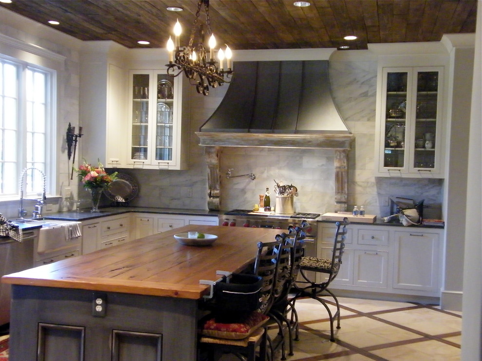 Example of a classic kitchen design in Birmingham with glass-front cabinets and wood countertops