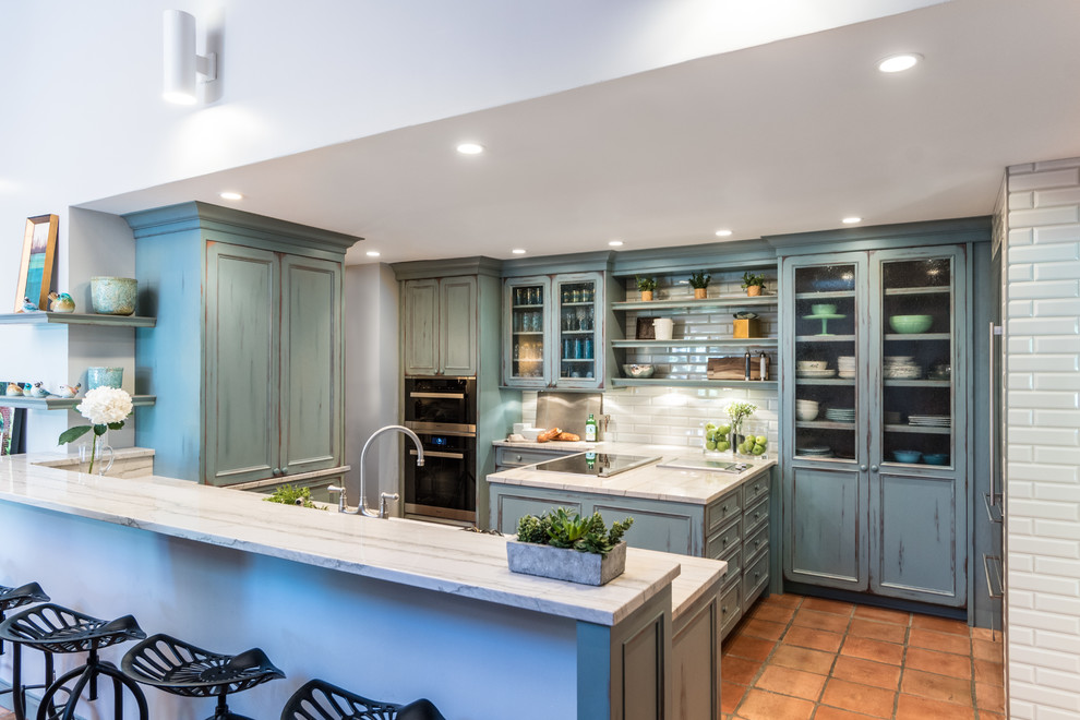 Design ideas for a rural kitchen in Indianapolis with recessed-panel cabinets, distressed cabinets, white splashback, stainless steel appliances, terracotta flooring and beige floors.