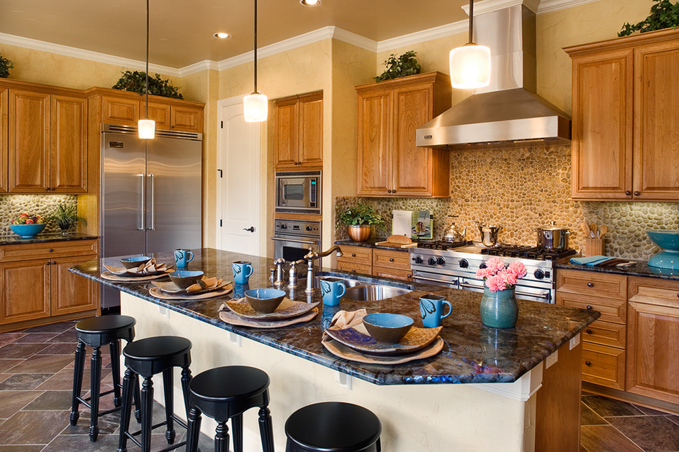 Inspiration for a mediterranean kitchen in Austin with raised-panel cabinets and stainless steel appliances.