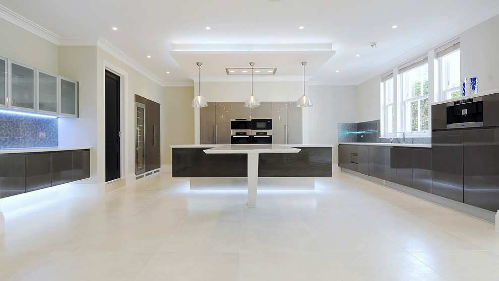 Photo of an expansive contemporary u-shaped open plan kitchen in London with an integrated sink, flat-panel cabinets, dark wood cabinets, composite countertops, metallic splashback, glass sheet splashback, integrated appliances, porcelain flooring and an island.