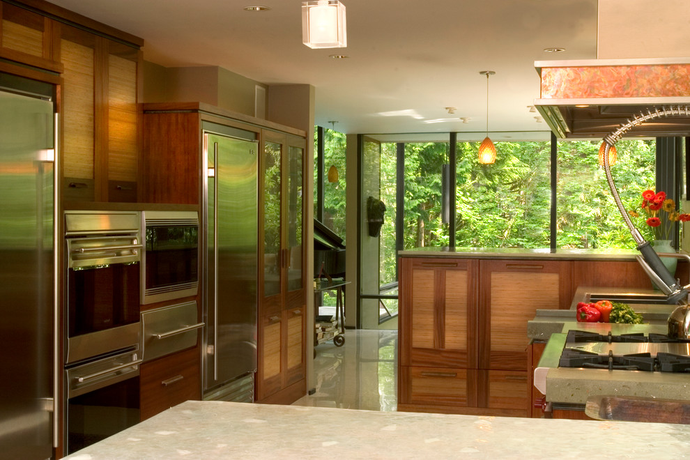 Exempel på ett stort modernt kök, med en dubbel diskho, släta luckor, skåp i mellenmörkt trä, bänkskiva i betong, svart stänkskydd, stänkskydd i cementkakel, rostfria vitvaror och klinkergolv i porslin