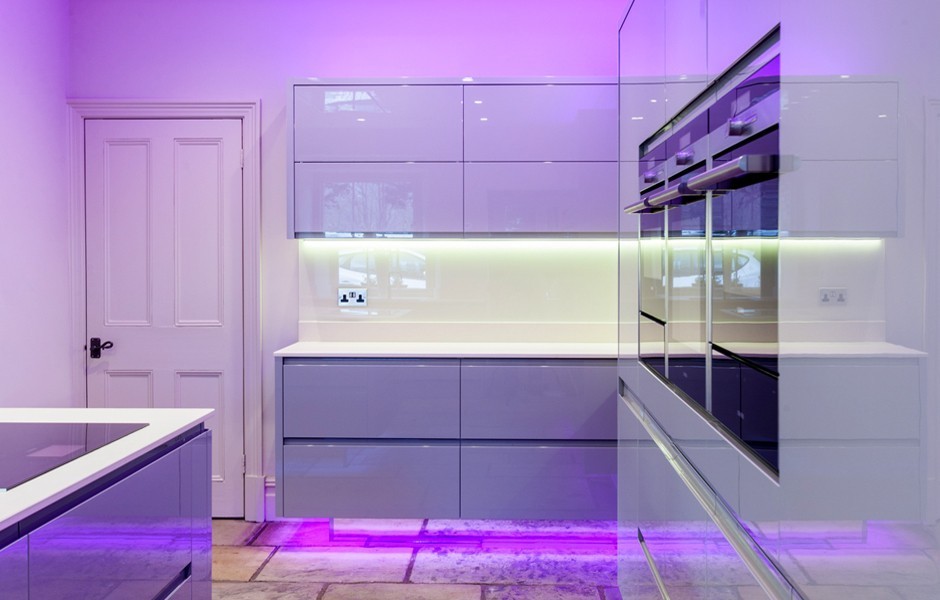 Immagine di una grande cucina minimalista con lavello da incasso, ante lisce, ante grigie, top in laminato, paraspruzzi bianco, elettrodomestici in acciaio inossidabile e pavimento in mattoni