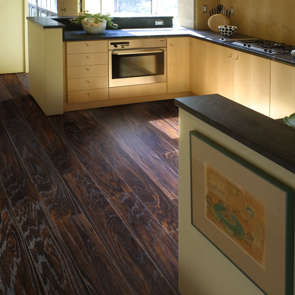Example of a small danish u-shaped dark wood floor and brown floor open concept kitchen design in Other with flat-panel cabinets, light wood cabinets, solid surface countertops, stainless steel appliances, no island and black countertops