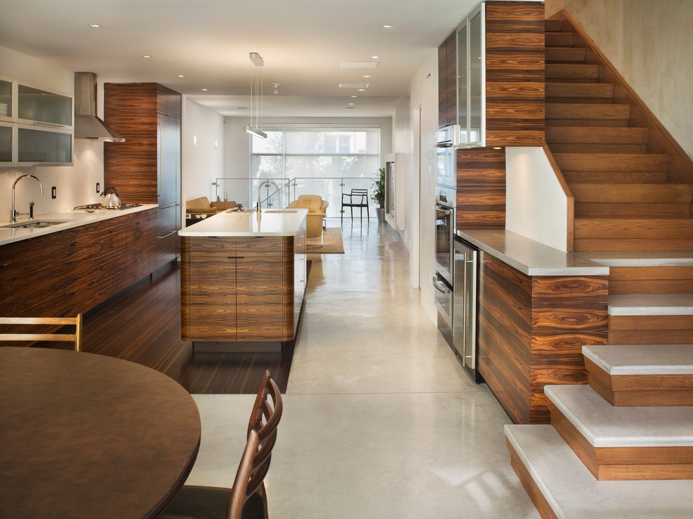 Moderne Wohnküche mit flächenbündigen Schrankfronten, hellbraunen Holzschränken und Küchengeräten aus Edelstahl in New York