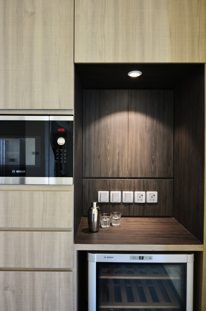 Cette image montre une cuisine design en bois clair avec un placard à porte plane.