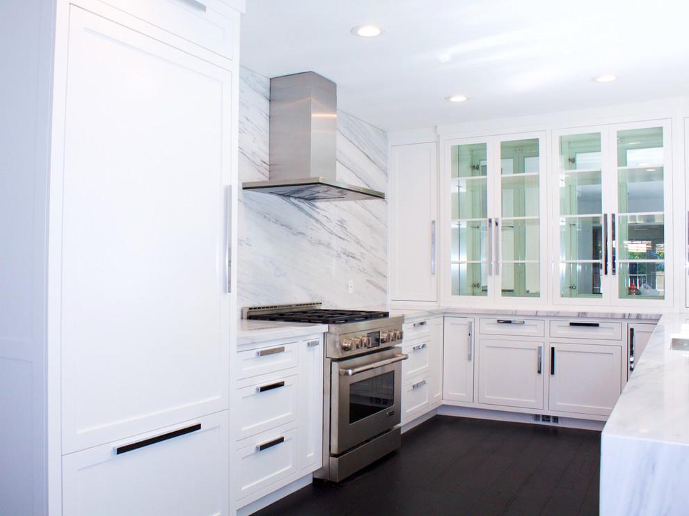Foto på ett mellanstort, avskilt funkis vit u-kök, med en undermonterad diskho, luckor med infälld panel, vita skåp, marmorbänkskiva, vitt stänkskydd, stänkskydd i sten, rostfria vitvaror, mörkt trägolv och brunt golv