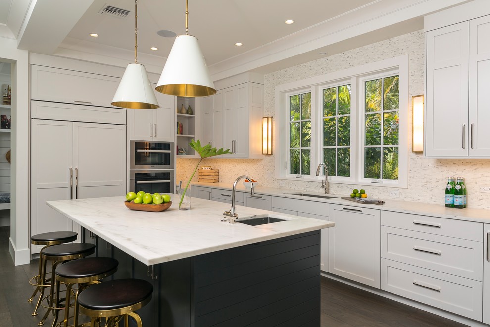 Eat-in kitchen - large transitional u-shaped medium tone wood floor and brown floor eat-in kitchen idea in Miami with shaker cabinets, white cabinets, marble countertops, white backsplash, stone tile backsplash, paneled appliances and an island