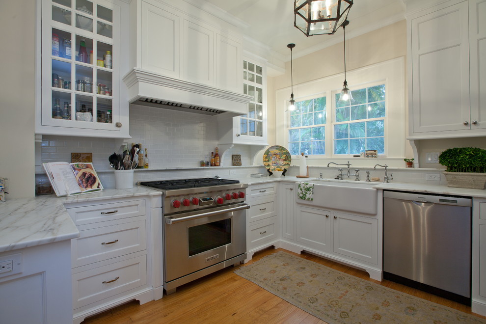 Modelo de cocina tradicional con armarios tipo vitrina, electrodomésticos de acero inoxidable y fregadero sobremueble