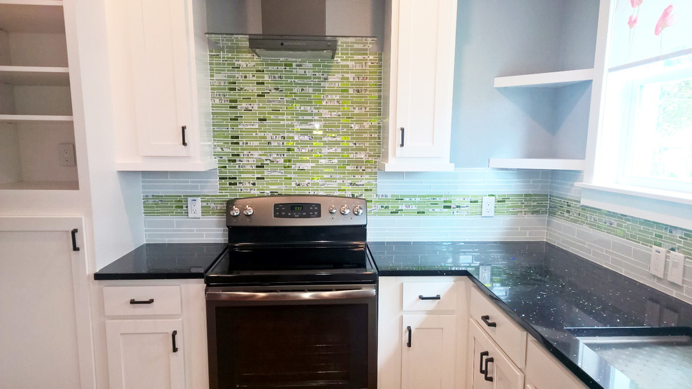 Mid-sized trendy u-shaped kitchen pantry photo in Miami with white cabinets, green backsplash, glass tile backsplash, stainless steel appliances and no island
