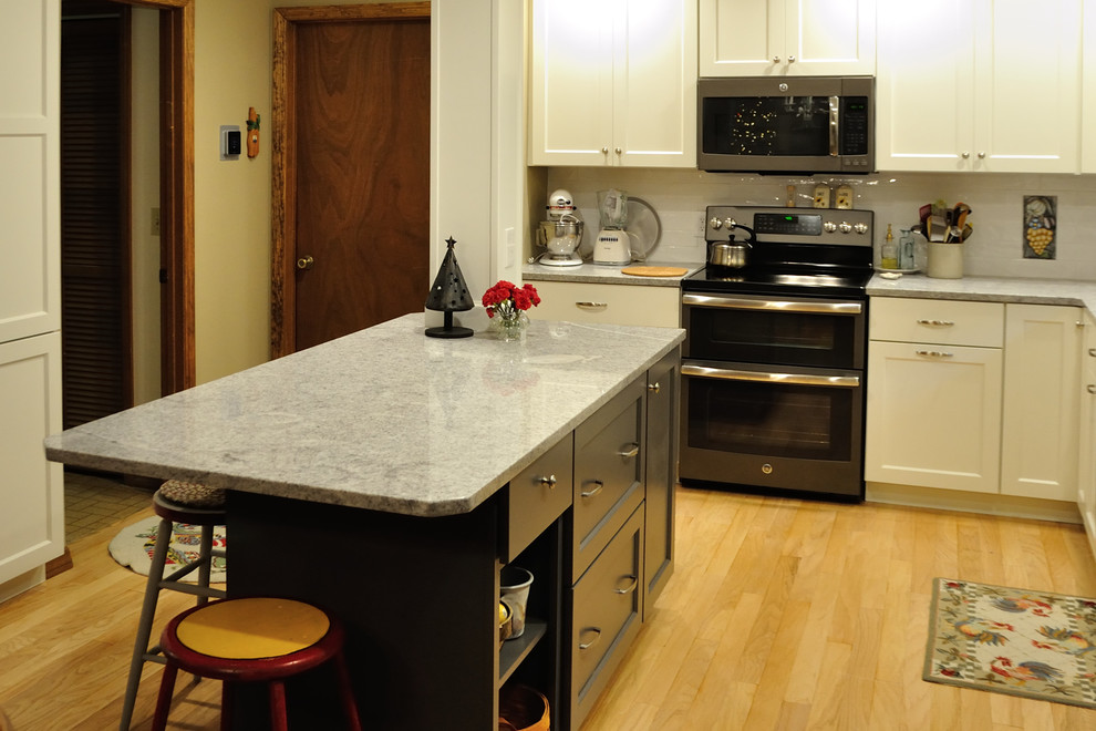 Bild på ett mellanstort vintage kök, med en undermonterad diskho, skåp i shakerstil, vita skåp, granitbänkskiva, vitt stänkskydd, stänkskydd i keramik, färgglada vitvaror, mellanmörkt trägolv och en köksö