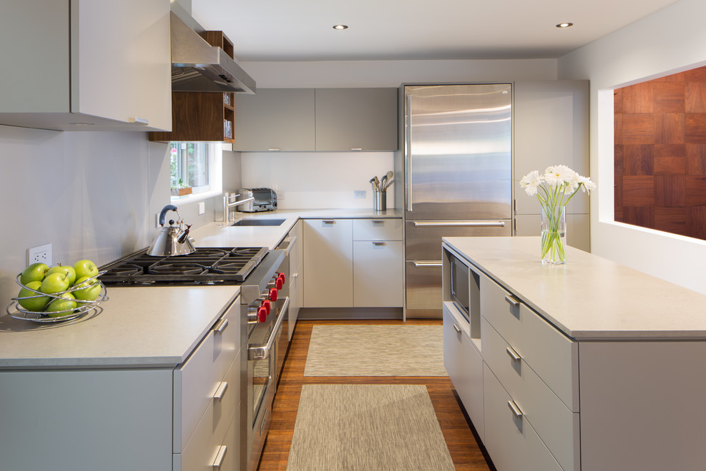 Exempel på ett mellanstort modernt kök, med en undermonterad diskho, grå skåp, bänkskiva i kvarts, grått stänkskydd, rostfria vitvaror, bambugolv och en köksö