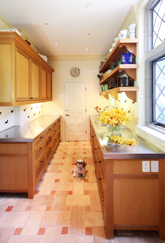 Cette image montre une cuisine parallèle traditionnelle en bois brun de taille moyenne avec un plan de travail en inox, une crédence blanche, une crédence en carreau de porcelaine, un sol en carrelage de céramique et un sol rose.