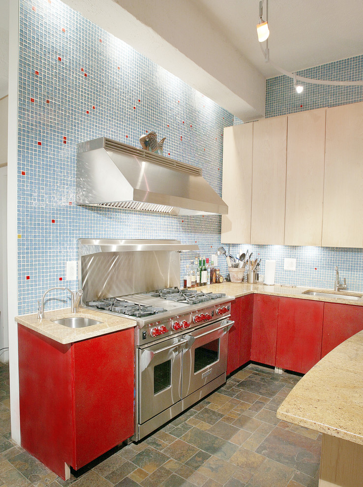 This is an example of a small contemporary u-shaped enclosed kitchen in New York with a submerged sink, flat-panel cabinets, red cabinets, composite countertops, blue splashback, glass tiled splashback, stainless steel appliances and terracotta flooring.