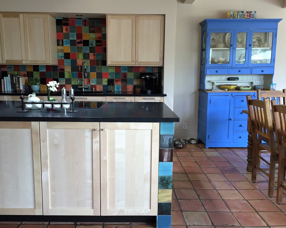 Bild på ett stort funkis kök, med en enkel diskho, luckor med infälld panel, skåp i ljust trä, bänkskiva i kvarts, flerfärgad stänkskydd, stänkskydd i keramik, rostfria vitvaror, klinkergolv i terrakotta och en köksö