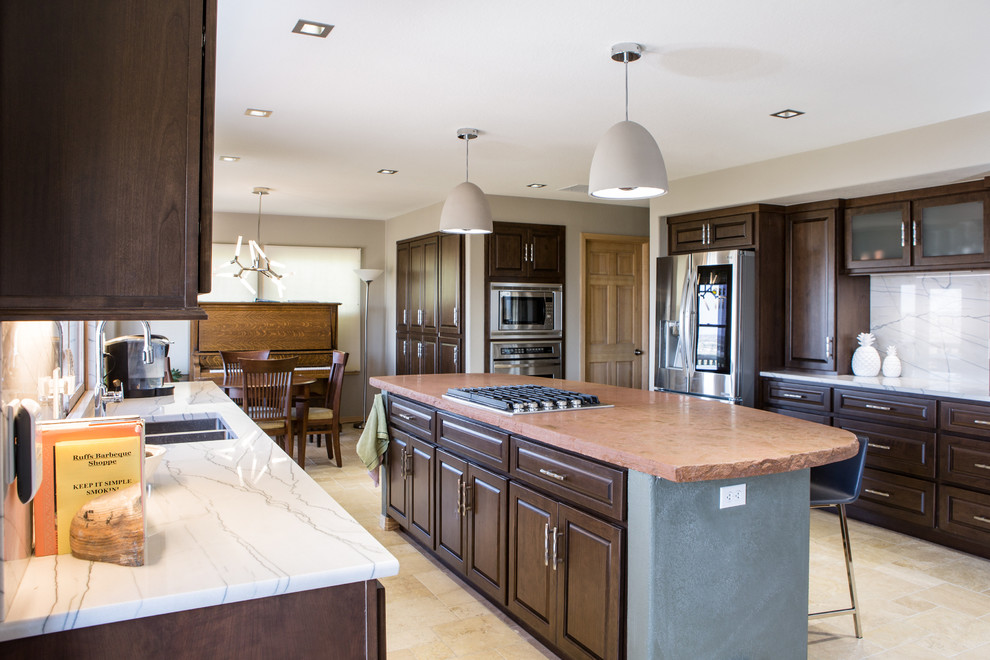 Diseño de cocina tradicional renovada, grande, con fregadero bajoencimera, armarios con paneles con relieve, puertas de armario de madera en tonos medios, encimera de cuarcita, salpicadero blanco, salpicadero de losas de piedra, electrodomésticos de acero inoxidable, suelo de travertino, una isla, suelo beige y encimeras blancas