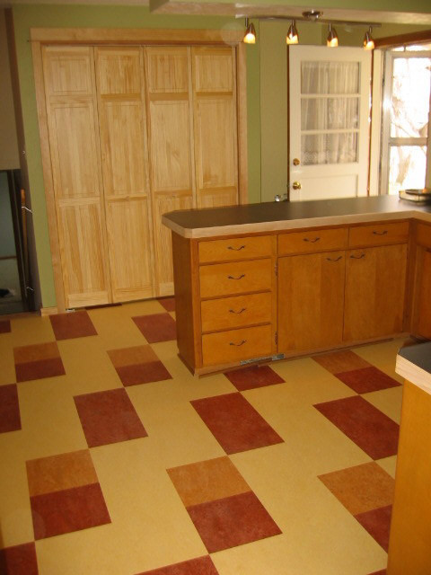 Ejemplo de cocina rústica de tamaño medio con puertas de armario blancas, suelo de linóleo, una isla y armarios con paneles lisos