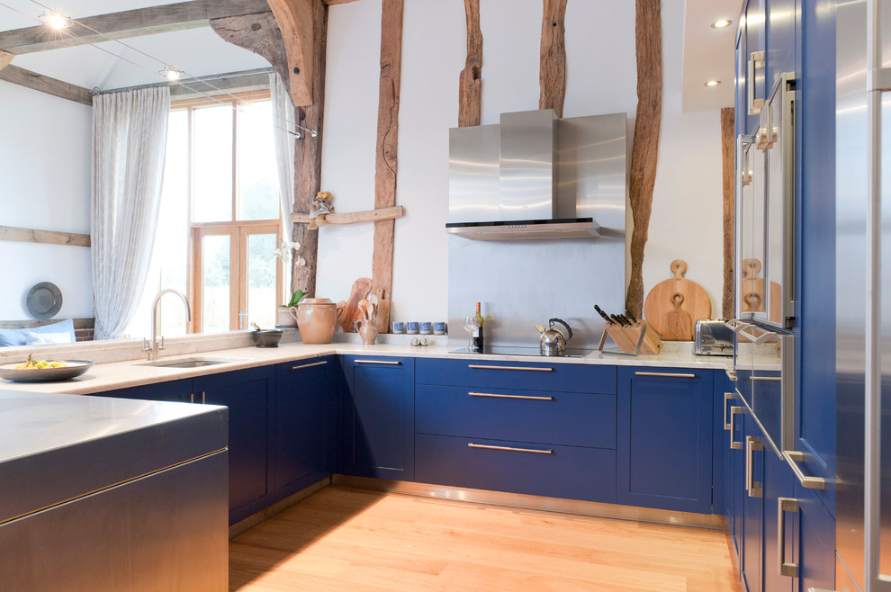 На фото: п-образная кухня в стиле кантри с синими фасадами