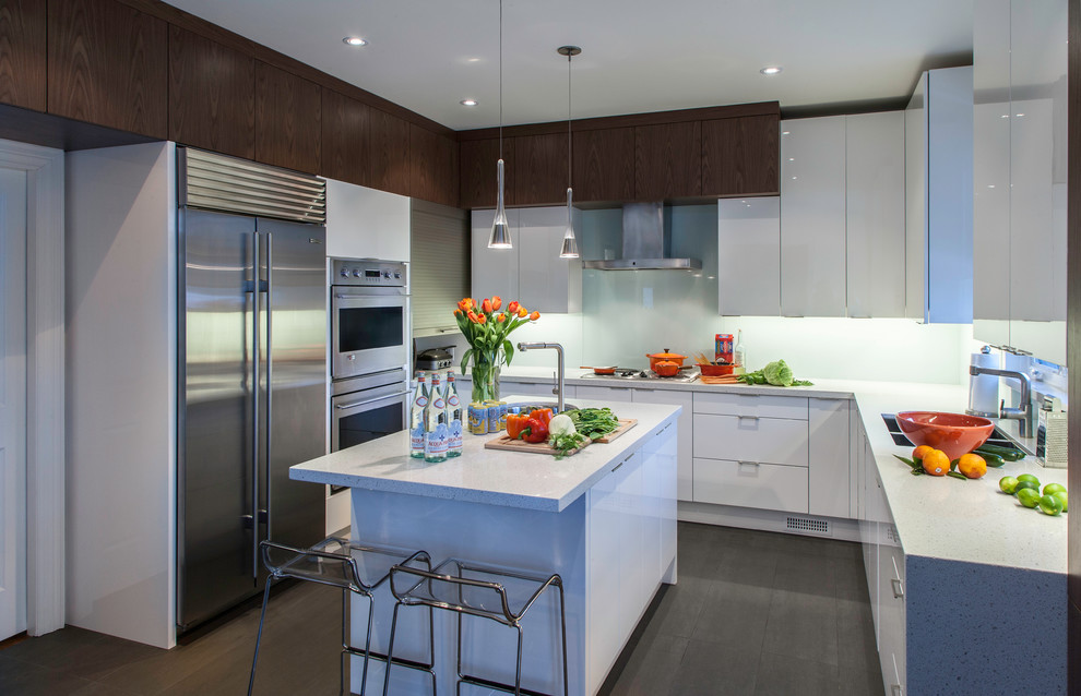 Inspiration for a contemporary u-shaped kitchen in Toronto with a submerged sink, flat-panel cabinets, white cabinets, engineered stone countertops, glass sheet splashback, stainless steel appliances and white splashback.