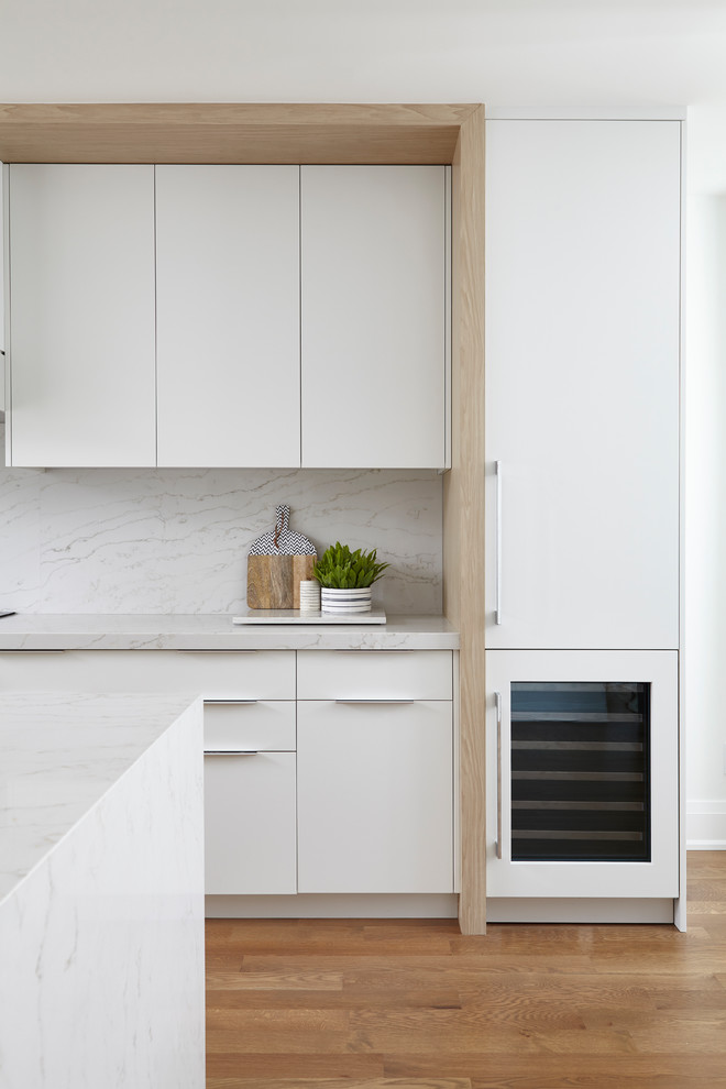 Exempel på ett mellanstort modernt grå grått kök, med en undermonterad diskho, släta luckor, vita skåp, bänkskiva i kvarts, grått stänkskydd, stänkskydd i sten, integrerade vitvaror, mellanmörkt trägolv, en köksö och brunt golv