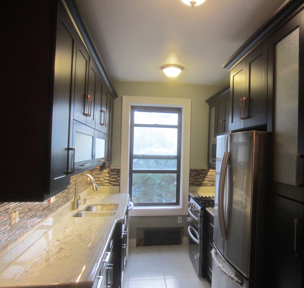 Photo of a small contemporary galley enclosed kitchen in New York with a double-bowl sink, shaker cabinets, brown cabinets, granite worktops, multi-coloured splashback, matchstick tiled splashback, stainless steel appliances, ceramic flooring, no island and white floors.