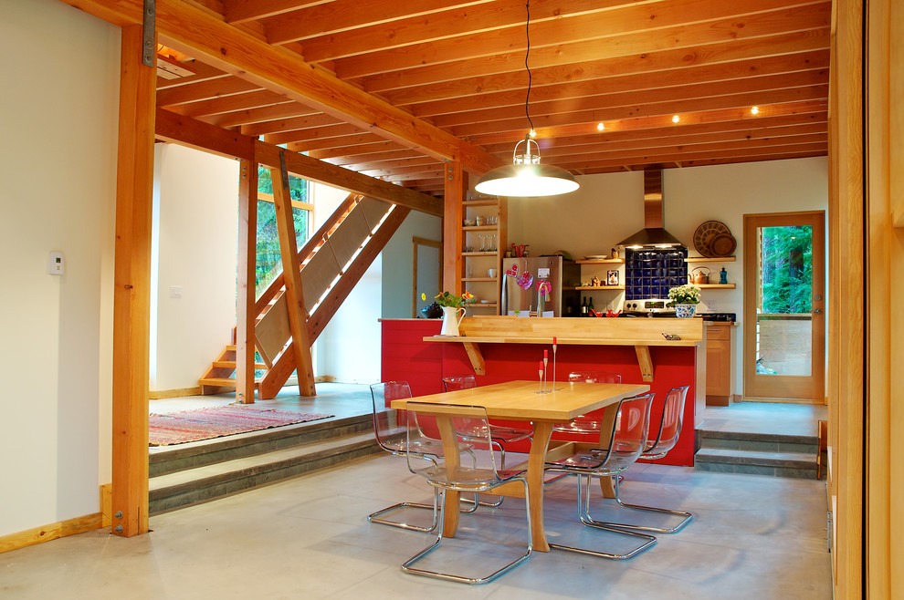Bild på ett funkis kök och matrum, med skåp i shakerstil, skåp i mellenmörkt trä, blått stänkskydd och rostfria vitvaror