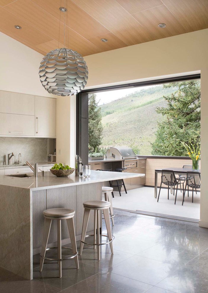 Zweizeilige Moderne Küche mit Unterbauwaschbecken, flächenbündigen Schrankfronten, grauen Schränken, Küchenrückwand in Grau, Rückwand aus Stein und Kücheninsel in Denver