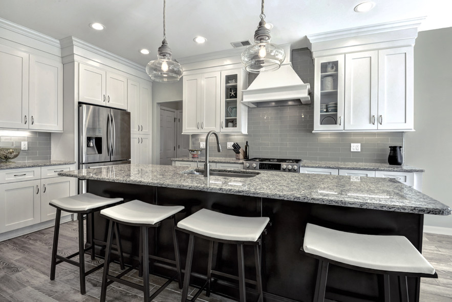 Exempel på ett stort modernt kök, med en undermonterad diskho, skåp i shakerstil, vita skåp, granitbänkskiva, grått stänkskydd, stänkskydd i glaskakel, rostfria vitvaror, klinkergolv i porslin, en köksö och brunt golv