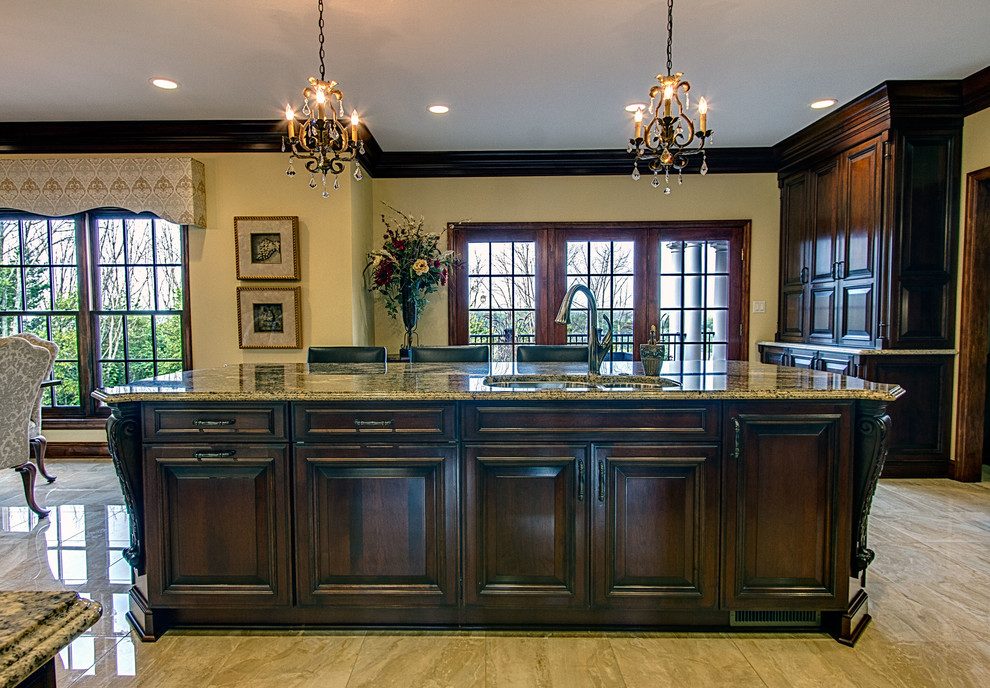 Eat-in kitchen - large traditional porcelain tile eat-in kitchen idea in Other with raised-panel cabinets, dark wood cabinets, granite countertops, beige backsplash, stone tile backsplash, paneled appliances and an island