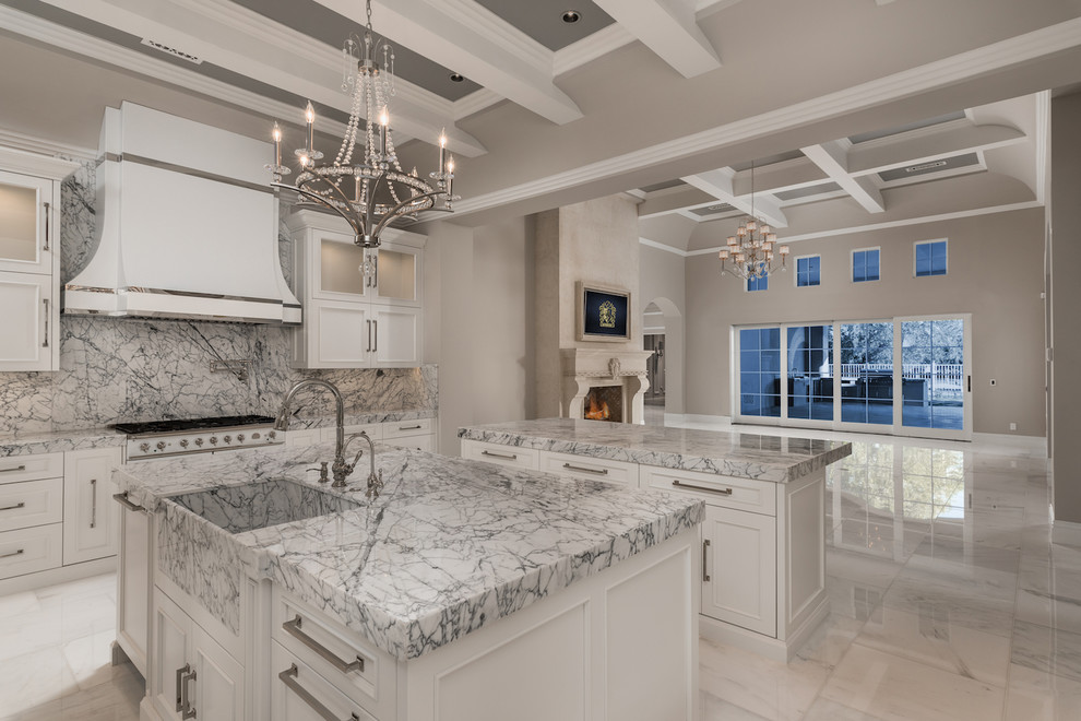 Huge tuscan u-shaped marble floor, multicolored floor and coffered ceiling enclosed kitchen photo in Phoenix with a farmhouse sink, recessed-panel cabinets, white cabinets, marble countertops, multicolored backsplash, marble backsplash, stainless steel appliances, two islands and multicolored countertops