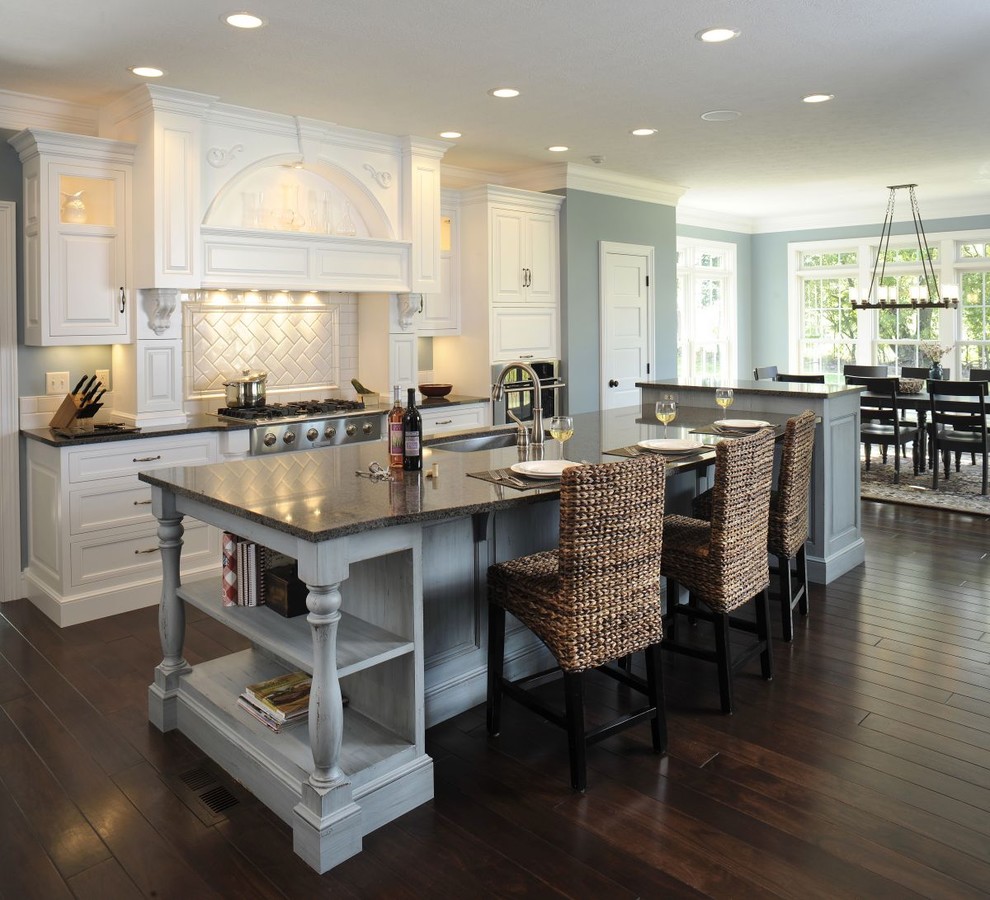 Imagen de cocina comedor clásica con electrodomésticos de acero inoxidable, salpicadero de azulejos tipo metro y barras de cocina