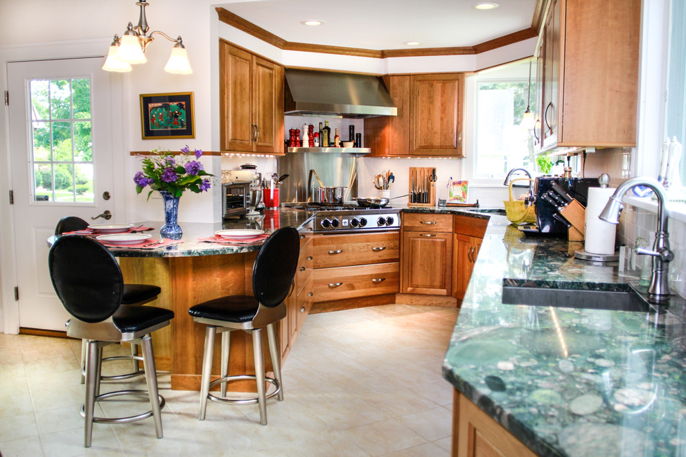 Foto på ett stort vintage kök, med en undermonterad diskho, luckor med upphöjd panel, skåp i mellenmörkt trä, granitbänkskiva, vitt stänkskydd, stänkskydd i keramik, rostfria vitvaror, klinkergolv i porslin och en halv köksö