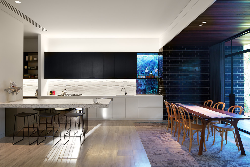 Zweizeilige, Mittelgroße Moderne Wohnküche mit Unterbauwaschbecken, flächenbündigen Schrankfronten, schwarzen Schränken, Küchenrückwand in Weiß und braunem Holzboden in Perth