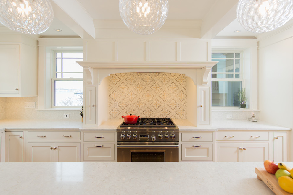 Inspiration for a large coastal medium tone wood floor kitchen remodel in Providence with an undermount sink, shaker cabinets, white cabinets, quartz countertops, white backsplash, paneled appliances, an island and white countertops