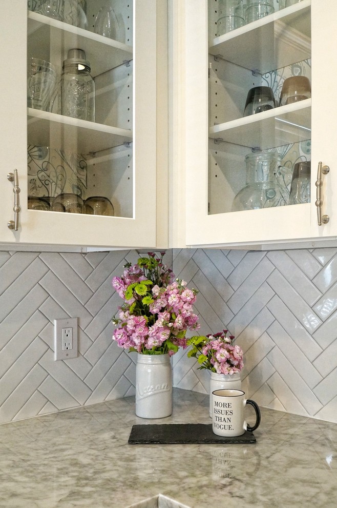 Enclosed kitchen - mid-sized shabby-chic style l-shaped porcelain tile and beige floor enclosed kitchen idea in Dallas with an undermount sink, white cabinets, marble countertops, white backsplash, porcelain backsplash, stainless steel appliances, an island and shaker cabinets