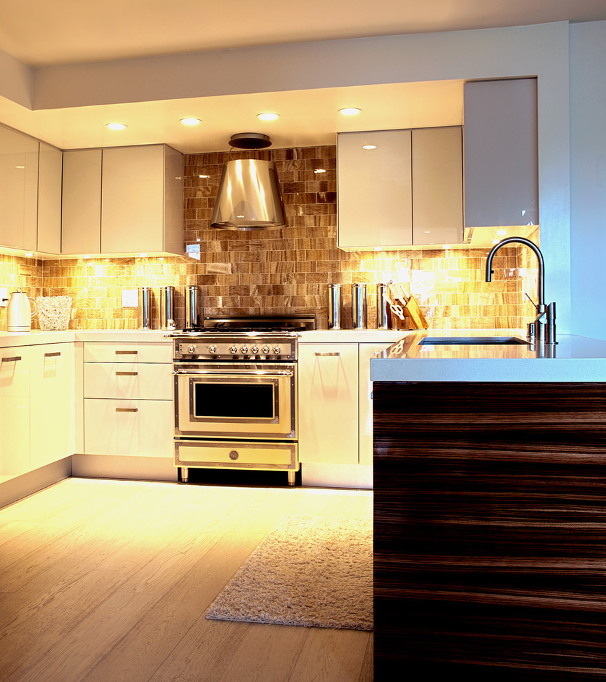 Foto de cocina actual con electrodomésticos blancos, armarios con paneles lisos, puertas de armario blancas, salpicadero de azulejos de piedra y salpicadero marrón