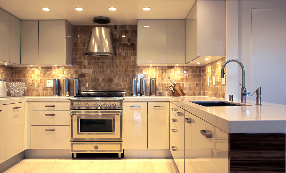Esempio di una cucina ad ambiente unico minimal con elettrodomestici in acciaio inossidabile, lavello sottopiano, ante lisce, ante bianche, paraspruzzi con piastrelle in pietra e paraspruzzi marrone