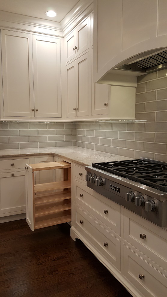 Inspiration for a large transitional l-shaped medium tone wood floor open concept kitchen remodel in Philadelphia with an undermount sink, recessed-panel cabinets, white cabinets, quartzite countertops, green backsplash, ceramic backsplash, paneled appliances and two islands