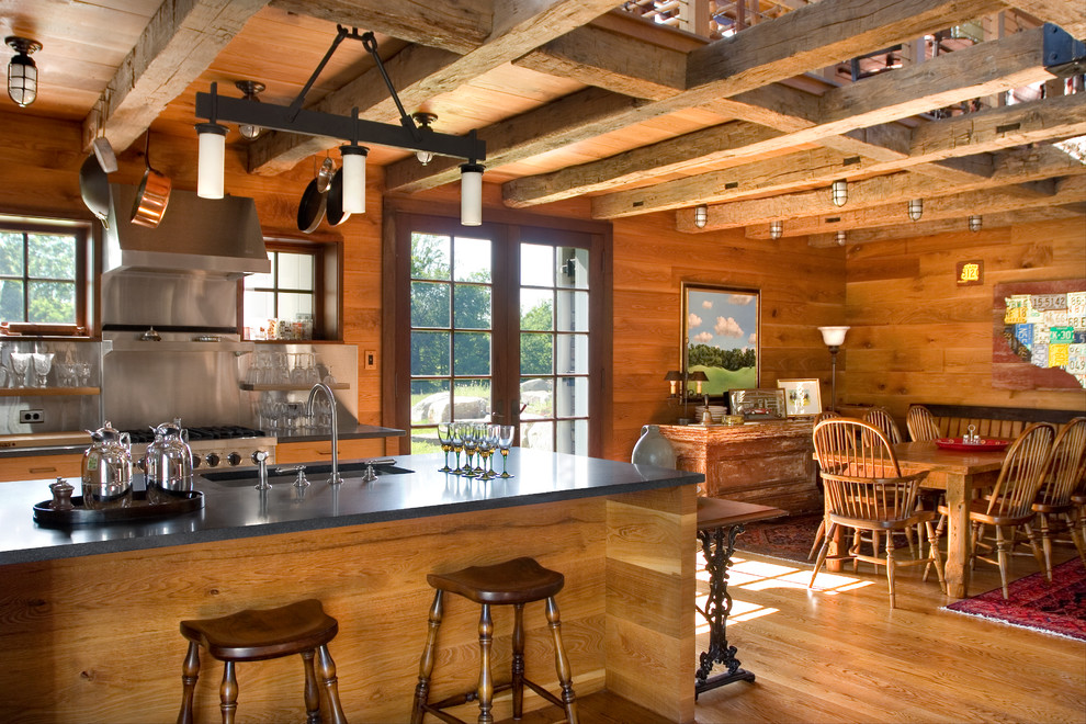 Foto på ett mellanstort lantligt kök och matrum, med öppna hyllor, skåp i mellenmörkt trä, en köksö, en undermonterad diskho, stänkskydd med metallisk yta, rostfria vitvaror, mellanmörkt trägolv och bänkskiva i täljsten